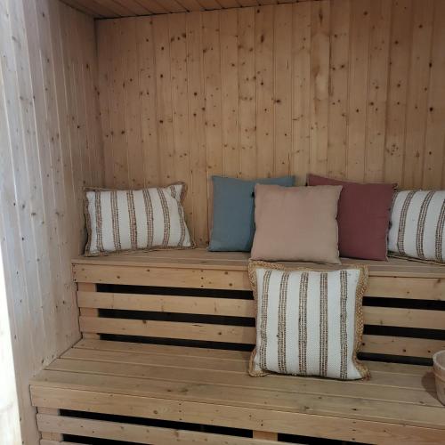 a wooden bench with pillows in a sauna at Hotel Bastide & SPA - Villa de Lourmarin in Lourmarin