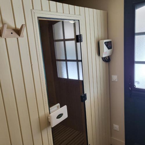 a bathroom with a door with a toilet paper dispenser at Hotel Bastide & SPA - Villa de Lourmarin in Lourmarin