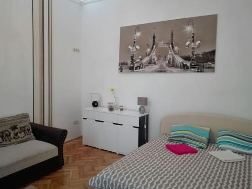 a bedroom with a bed and a dresser in it at Sunshine flat at the BLAHA in Budapest