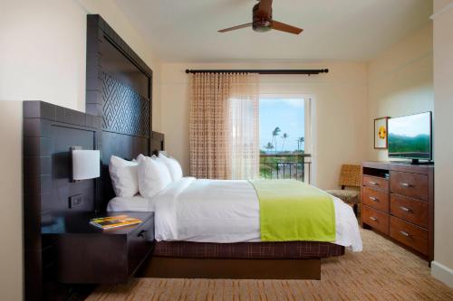 a bedroom with a large bed and a television at Marriott's Waiohai Beach Club in Koloa