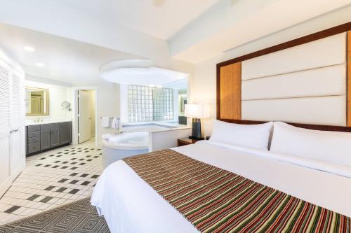 - une chambre d'hôtel avec un lit et une baignoire dans l'établissement Marriott's Imperial Palms Villas, à Orlando