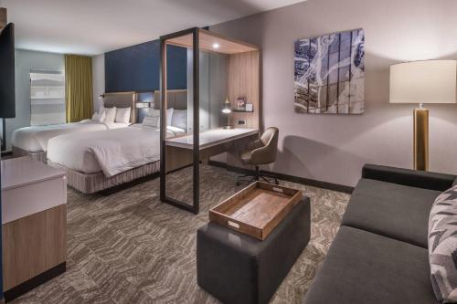 a hotel room with two beds and a couch at SpringHill Suites by Marriott Reno in Reno