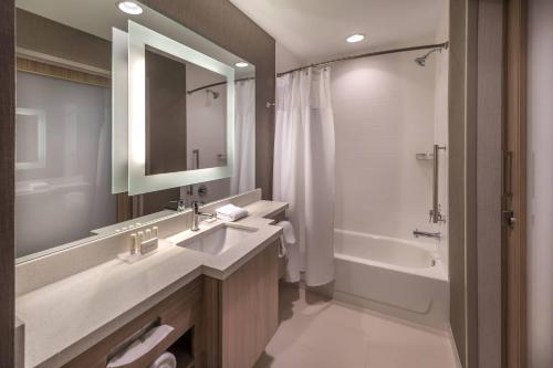 a bathroom with a sink and a tub and a mirror at SpringHill Suites by Marriott Reno in Reno