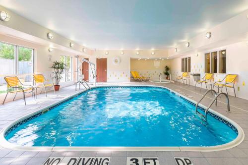 a large swimming pool in a room with chairs at Fairfield Inn & Suites Holland in Holland