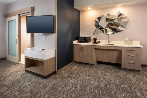 フレデリックにあるSpringHill Suites By Marriott Frederickのデスクとテレビが備わる客室です。