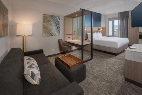 フレデリックにあるSpringHill Suites By Marriott Frederickのソファとベッド付きのホテルルーム