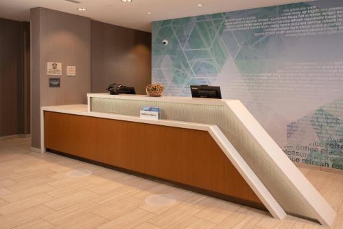 a lobby with a reception desk and a large screen at SpringHill Suites By Marriott Frederick in Frederick
