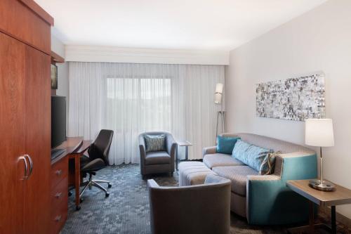 un soggiorno con divano e scrivania di Courtyard by Marriott Pittsburgh Washington Meadow Lands a Washington