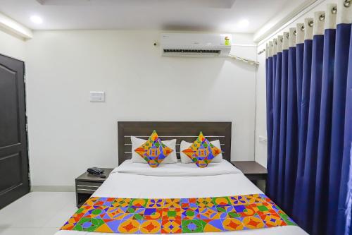 a bedroom with a bed with blue curtains at FabHotel Villa 31 in Nagpur