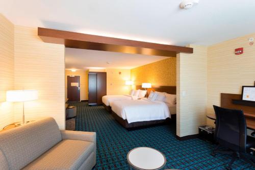 a hotel room with a bed and a couch at Fairfield Inn & Suites by Marriott Decorah in Decorah