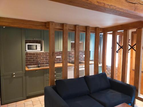 un salon avec un canapé et une cuisine dans l'établissement Charme et confort à proximité du vieux bassin, à Honfleur