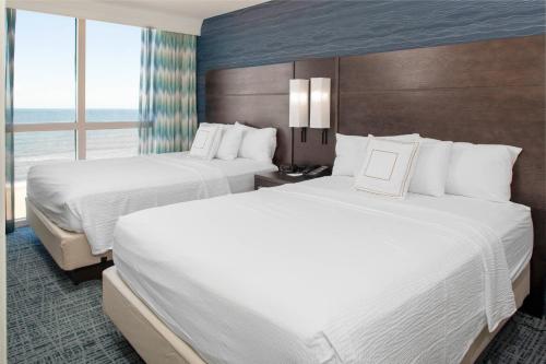 a hotel room with two beds and a window at Residence Inn By Marriott Virginia Beach Oceanfront in Virginia Beach