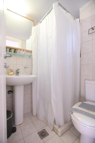 a bathroom with a white shower curtain and a sink at Seaside Gialova in Pylos