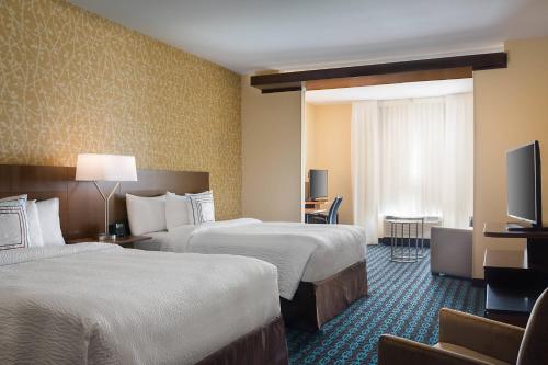 a hotel room with two beds and a flat screen tv at Fairfield Inn & Suites by Marriott Dallas West/I-30 in Dallas