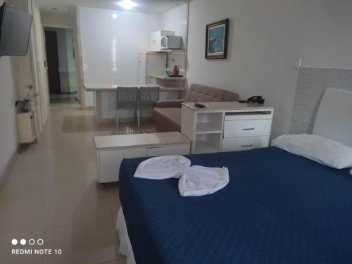 1 dormitorio con 1 cama azul y cocina en Flat Na Barra, en Salvador