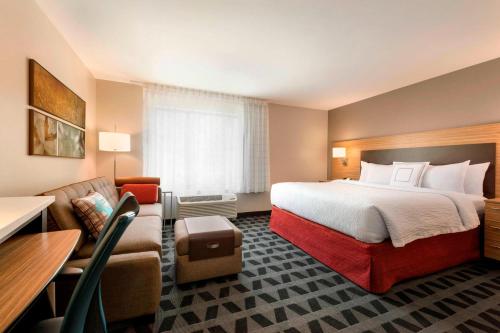 a hotel room with a large bed and a couch at TownePlace Suites by Marriott Pittsburgh Airport/Robinson Township in Robinson Township