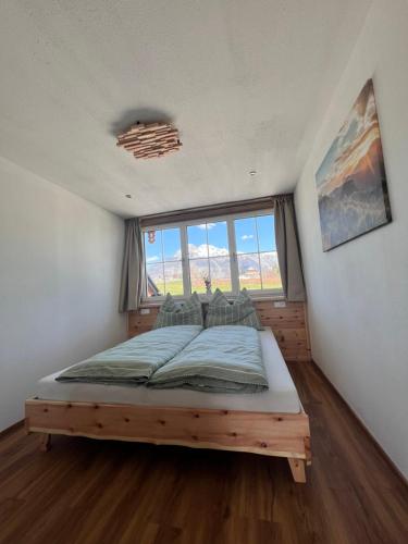 a bed in a room with a large window at S‘Lieblingsplatzl in Bad Aussee