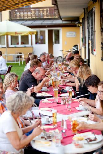 a group of people sitting at long tables eating at Hotel Restaurant Platzer in Gmünd in Kärnten