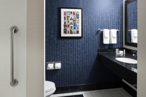 a blue bathroom with a sink and a toilet at Fairfield Inn & Suites South Bend at Notre Dame in South Bend