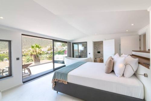 a bedroom with a large bed and large windows at Gorgeous 3 Bedroom Property at Kalamar Bay in Kalkan