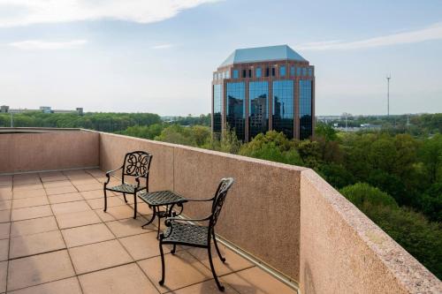 two chairs and a table on a balcony with a building at Falls Church Marriott Fairview Park in Falls Church