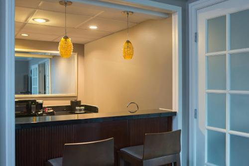 a bar with two chairs and a mirror at Falls Church Marriott Fairview Park in Falls Church