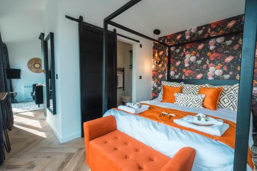 - une chambre avec un grand lit et une chaise orange dans l'établissement Priory Bay Escapes - Visum, à Tenby