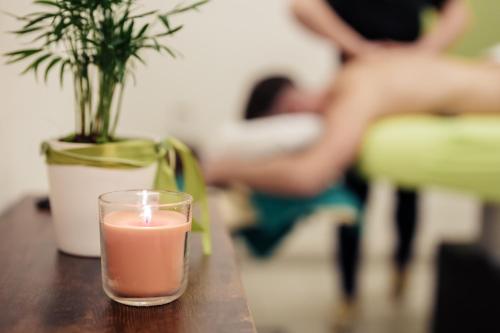 a candle sitting on a table with a potted plant at Jura Sport & Spa Resort in Saignelégier