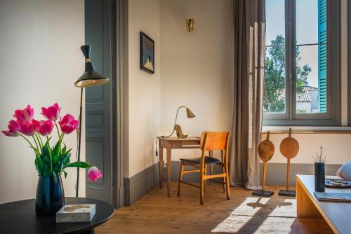 ein Wohnzimmer mit einem Schreibtisch und einem Tisch mit Blumen in der Unterkunft LE LANTERNON in Saint-Martin-de-Ré