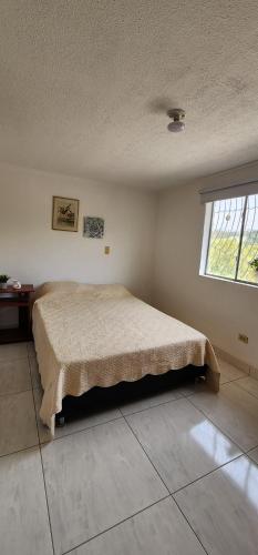 a bedroom with a bed in a room with a window at Casa Campestre Las Margaritas 