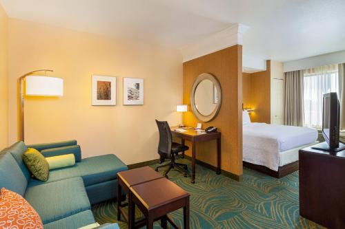 a hotel room with a bed and a living room at SpringHill Suites by Marriott Modesto in Modesto