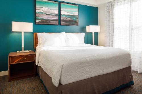 a large bed in a hotel room with two lamps at Residence Inn Salt Lake City Cottonwood in Cottonwood Heights