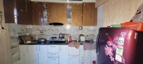 uma cozinha com armários de madeira e um frigorífico em POP Home Zohan Homestay em Jamu