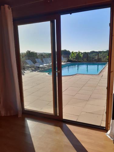 a sliding glass door with a view of a swimming pool at La voie de l'hirondelle in Saint-Léon-sur-Vézère