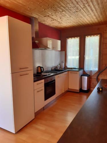 a kitchen with white appliances and a white refrigerator at La voie de l'hirondelle in Saint-Léon-sur-Vézère