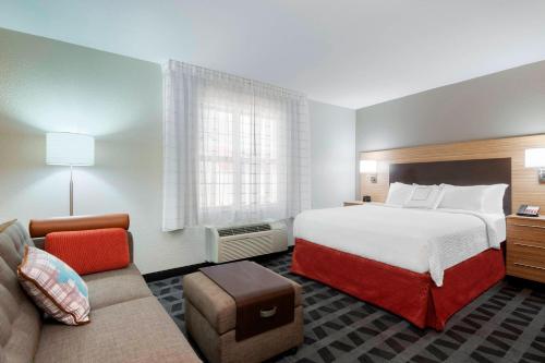 a hotel room with a bed and a couch at TownePlace Suites Savannah Midtown in Savannah