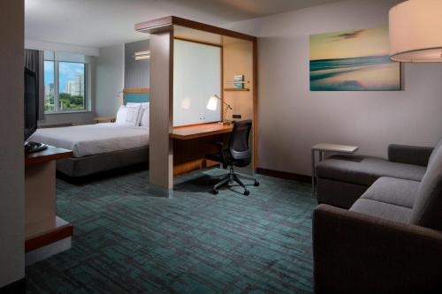 マイアミにあるSpringHill Suites Miami Downtown/Medical Centerのベッド、デスク、コンピュータが備わるホテルルームです。