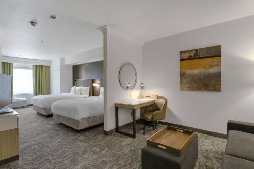 a hotel room with two beds and a desk and a mirror at SpringHill Suites by Marriott Sacramento Natomas in Sacramento