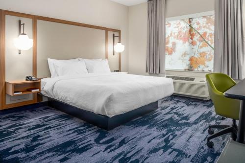 a hotel room with a bed and a desk and a window at Fairfield by Marriott Inn & Suites Kansas City North, Gladstone in Kansas City