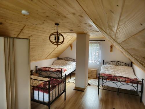 two bunk beds in a room with a wooden ceiling at Domek na Wzgórzu in Zahoczewie