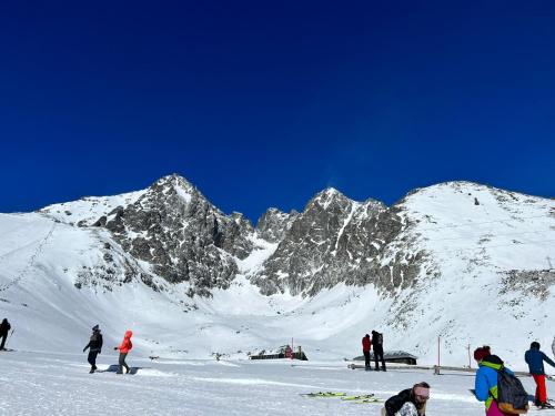 un grupo de personas esquiando en una montaña cubierta de nieve en CHATA ŠEFEC holiday resort Východná, en Východná