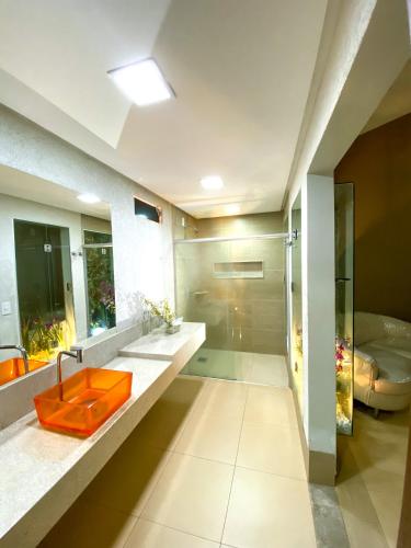 a bathroom with an orange sink and a tub at Rodotel Vênus Prime in Rio Verde