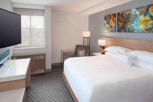 a hotel room with a bed and a flat screen tv at Delta Hotels by Marriott Seattle Everett in Everett