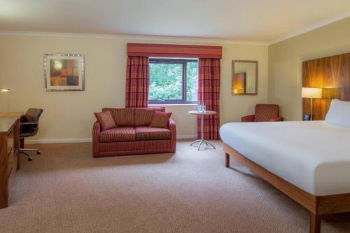 Habitación de hotel con cama, silla y escritorio. en Delta Hotels by Marriott Milton Keynes, en Milton Keynes