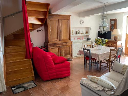 un salon avec une chaise rouge et une table dans l'établissement L’aire vieille, à Pommiers