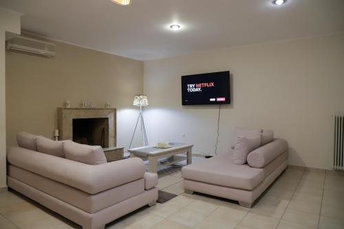 a living room with two couches and a tv at Perfect home for Relaxing in Artemida