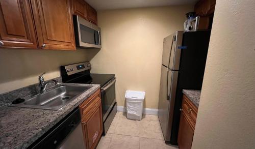 uma pequena cozinha com um lavatório e um frigorífico em Gulfstream Manor em Delray Beach