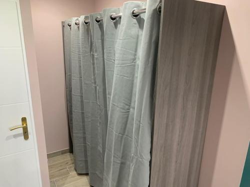 una tenda da doccia in un bagno accanto a una porta di Villa piscine/spa privé intérieur 33° ZOO DE LA FLECHE 24h DU MANS a La Flèche