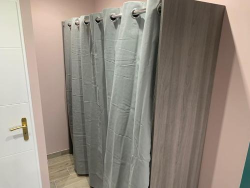 a shower curtain in a bathroom next to a door at Villa piscine/spa privé intérieur 33° ZOO DE LA FLECHE 24h DU MANS in La Flèche