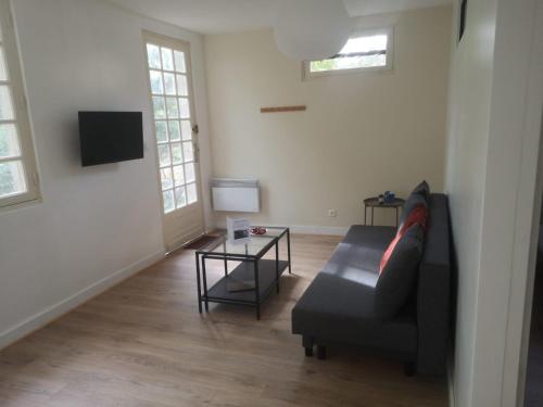 a living room with a couch and a table at Petite maison avec jardin in Montcaret